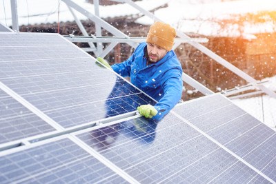 Solar-Installateur befestigt Panels im Winter.
